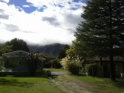 a yard with a house and a mountain in the background at Samai Suma Cabañas & Spa in Villa General Belgrano