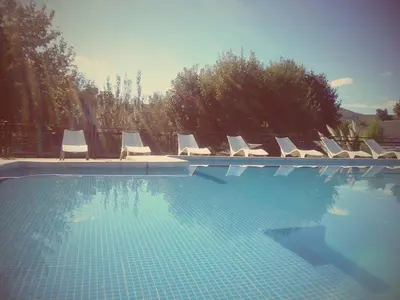 a swimming pool with a bunch of lounge chairs at Samai Suma Cabañas & Spa in Villa General Belgrano