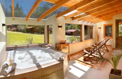 a large tub in a room with a large window at Samai Suma Cabañas & Spa in Villa General Belgrano