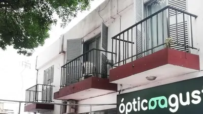 a building with a balcony and a sign on it at Departamentos Buena Onda in Villa Carlos Paz