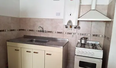 a small kitchen with a stove and a sink at Departamentos Buena Onda in Villa Carlos Paz