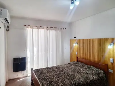 a bedroom with a bed and a window at Departamentos Buena Onda in Villa Carlos Paz