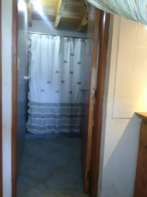 a bathroom with a shower with a shower curtain at Cabaña Los Angeles in Villa General Belgrano