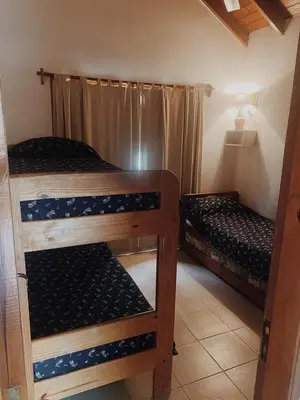 a room with two bunk beds in a room at Cabaña Los Angeles in Villa General Belgrano