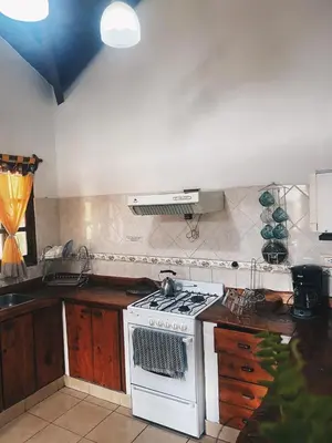 a kitchen with a white stove top oven at Cabaña Los Angeles in Villa General Belgrano