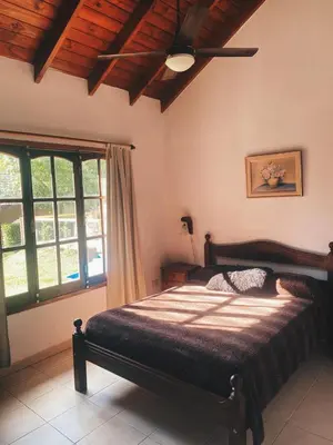 a bedroom with a bed and a large window at Cabaña Los Angeles in Villa General Belgrano