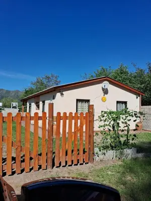 a house behind a wooden fence with a house at Casa del Sol in Santa María