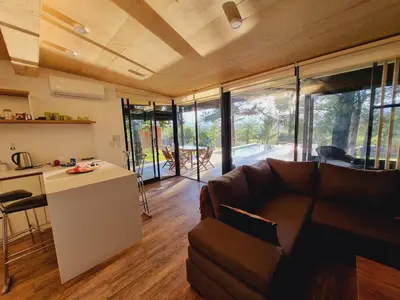 a kitchen and a living room with a couch and a table at Colores de Manantiales in Villa General Belgrano
