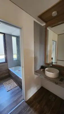 a bathroom with a sink and a mirror and a tub at Colores de Manantiales in Villa General Belgrano