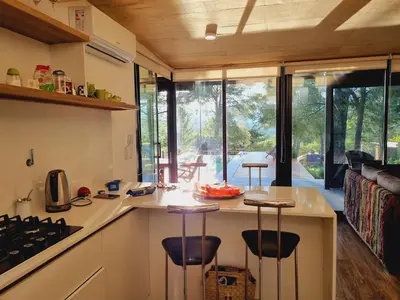 a kitchen with a counter with stools around it at Colores de Manantiales in Villa General Belgrano
