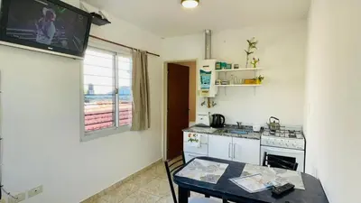 a kitchen with a table and a tv on the wall at Deptos carlos paz in Villa Carlos Paz