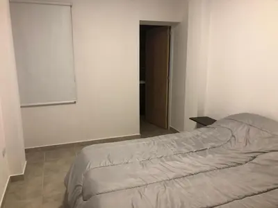 an empty bedroom with a bed and a window at Deptos carlos paz in Villa Carlos Paz