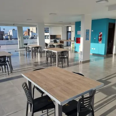 a cafeteria with tables and chairs in a building at Moderno Dpto Centrico in Villa Carlos Paz