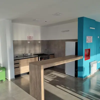 a kitchen with a wooden table in a room at Moderno Dpto Centrico in Villa Carlos Paz