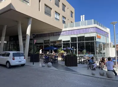 a building with people sitting at tables outside of it at Moderno Dpto Centrico in Villa Carlos Paz