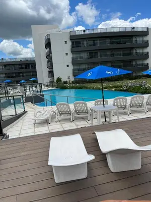 a patio with a table and chairs and an umbrella at Departamento Veneto Village - K - in Villa Parque Siquiman