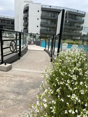 a walkway with white flowers in front of a building at Departamento Veneto Village - K - in Villa Parque Siquiman