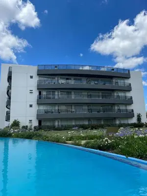 a building with a swimming pool in front of a building at Departamento Veneto Village - K - in Villa Parque Siquiman