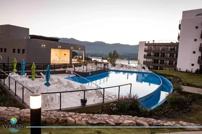 a large swimming pool in front of a building at Departamento Veneto Village - K - in Villa Parque Siquiman