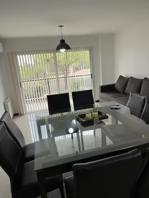 a living room with a glass table and a couch at Departamento Veneto Village - B in Villa Parque Siquiman