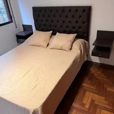 a bedroom with a large bed with a black headboard at Eugenio Garzón 448 in Cordoba