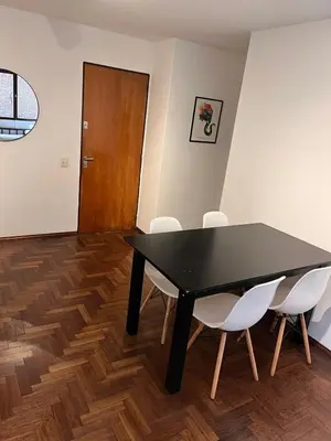 a dining room with a black table and white chairs at Eugenio Garzón 448 in Cordoba