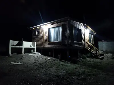 a small wooden cabin with a light on it at night at Villa Nicolasa in Villa Yacanto