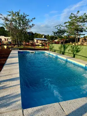 a swimming pool with blue water in a yard at Villa Nicolasa in Villa Yacanto