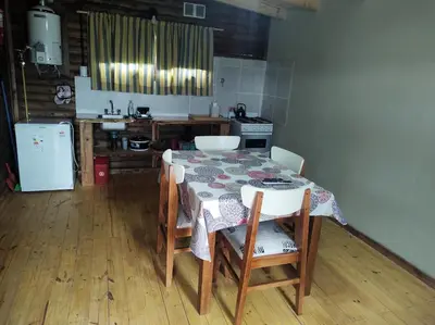a kitchen with a table and chairs and a kitchen with a refrigerator at Villa Nicolasa in Villa Yacanto
