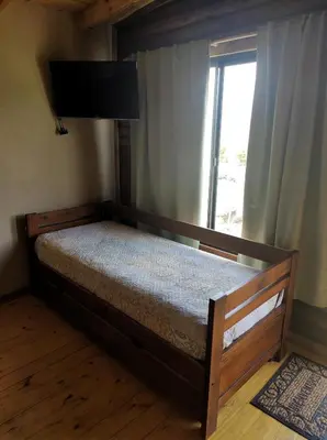 a bedroom with a wooden bed with a window at Villa Nicolasa in Villa Yacanto