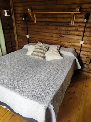 a bed in a room with a wooden wall at Villa Nicolasa in Villa Yacanto