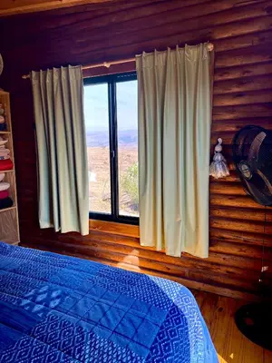 a bedroom with a bed and a large window at Villa Nicolasa in Villa Yacanto