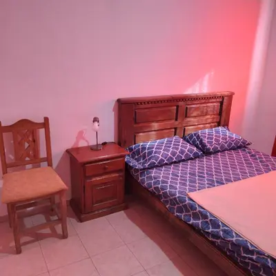 a bedroom with a bed and a chair and a table at Casa de Julia in Cordoba
