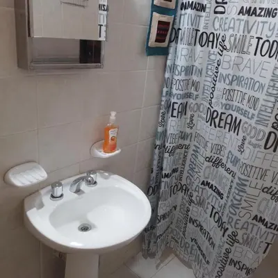 a bathroom with a sink and a shower curtain at Casa de Julia in Cordoba
