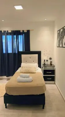a bedroom with a large bed with a black headboard at Casa Naranja habitaciones privadas in Cordoba