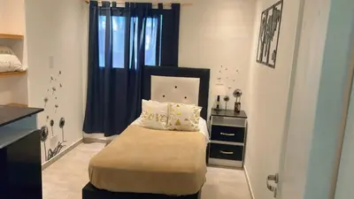 a bedroom with a bed with a black headboard and a window at Casa Naranja habitaciones privadas in Cordoba