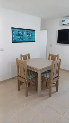 a dining room table with two chairs and a television at tu lugar 2 in Cordoba