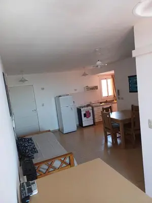a small kitchen with a table and a refrigerator at tu lugar 2 in Cordoba