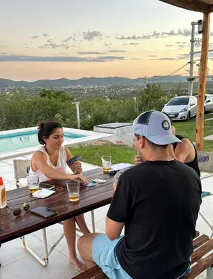 a man and a woman sitting at a picnic table at Casa Carlos Paz, 6 personas in Estancia Vieja