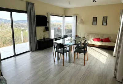 a living room with a table and chairs and a couch at Casa Carlos Paz, 6 personas in Estancia Vieja