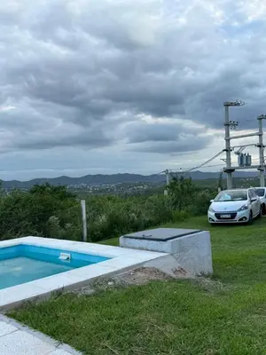 a white car parked next to a swimming pool at Casa Carlos Paz, 6 personas in Estancia Vieja