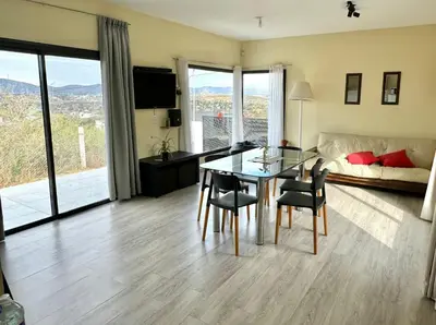 a living room with a table and chairs and a couch at Casa Carlos Paz, 6 personas in Estancia Vieja