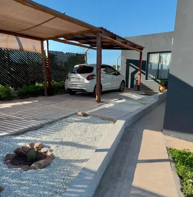 a car parked under a cover in a parking lot at Casa Carlos Paz, 6 personas in Estancia Vieja