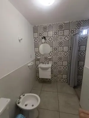 a bathroom with a toilet and a sink and a mirror at Aire de las Sierras in Embalse