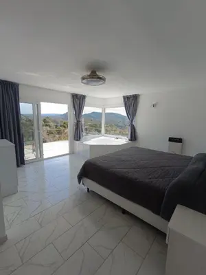 a bedroom with a bed and a large window at Aire de las Sierras in Embalse