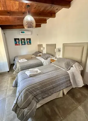 a bedroom with three beds in a room at Cabaña Sierras Chicas in Villa Anizacate