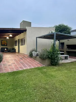 a house with a patio and an umbrella at Cabaña Sierras Chicas in Villa Anizacate