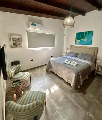 a bedroom with a bed and a table and chairs at Cabaña Sierras Chicas in Villa Anizacate