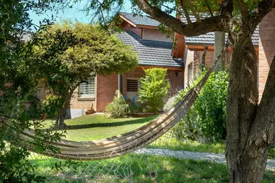 a hammock in front of a house at Cabaña para relajarse con vista panorámica in Villa General Belgrano