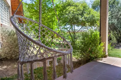 a metal swing hanging from a porch at Cabaña para relajarse con vista panorámica in Villa General Belgrano
